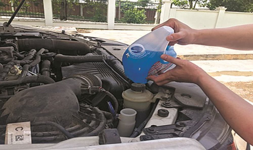 Sử dụng dung dịch nước lau kính xe ô tô chuyên dụng để châm thêm cho bình chứa